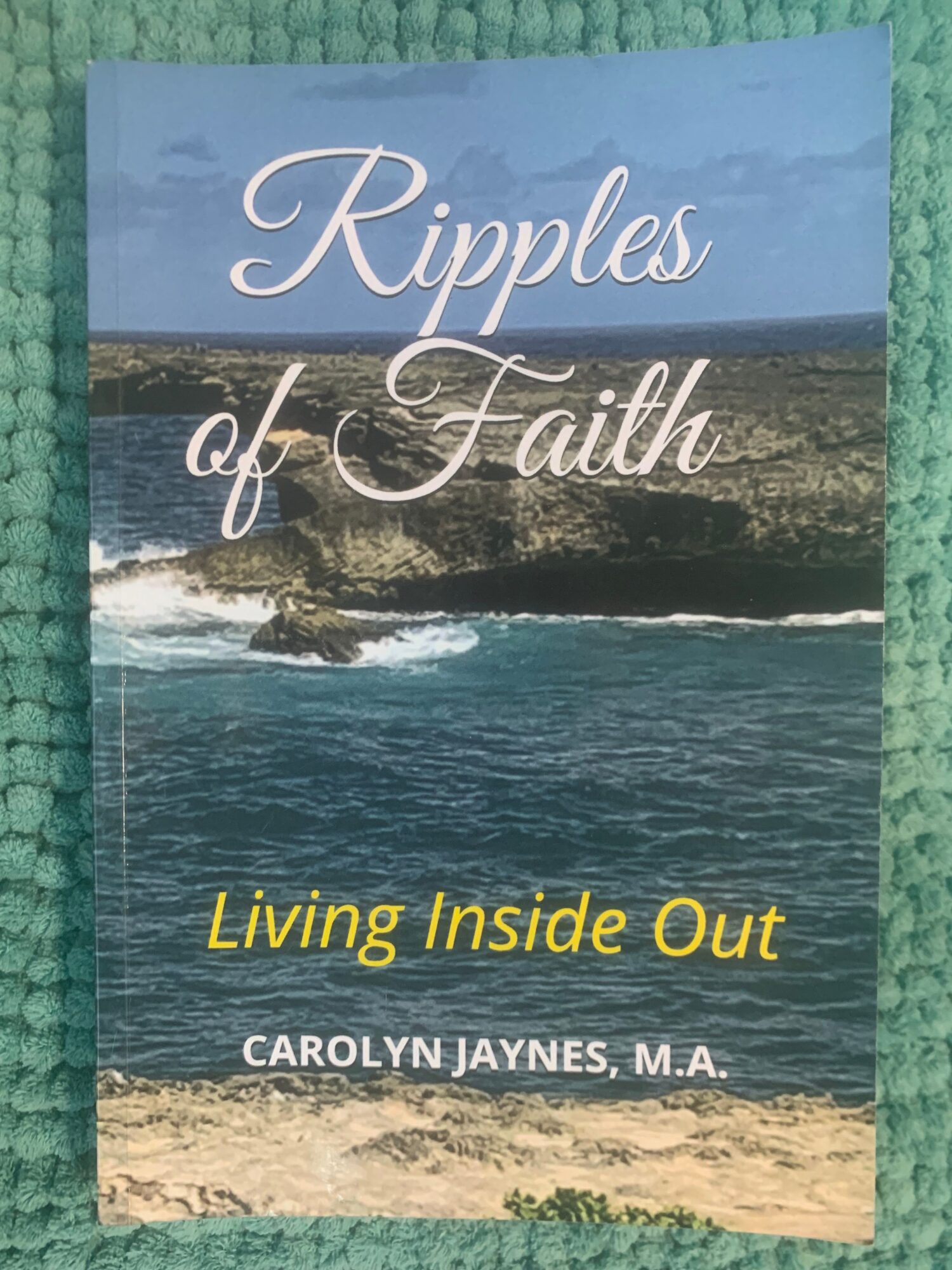 Book cover titled 'Ripples of Faith' with a coastal landscape and the subtitle 'Living Inside Out' by Carolyn Jaynes, M.A.