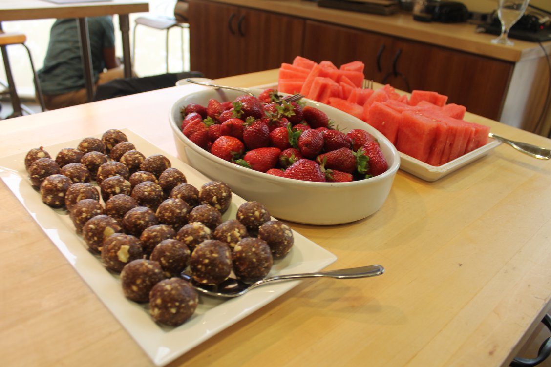 Assorted fruits including strawberries, watermelon slices, and chocolate-covered treats on a table.