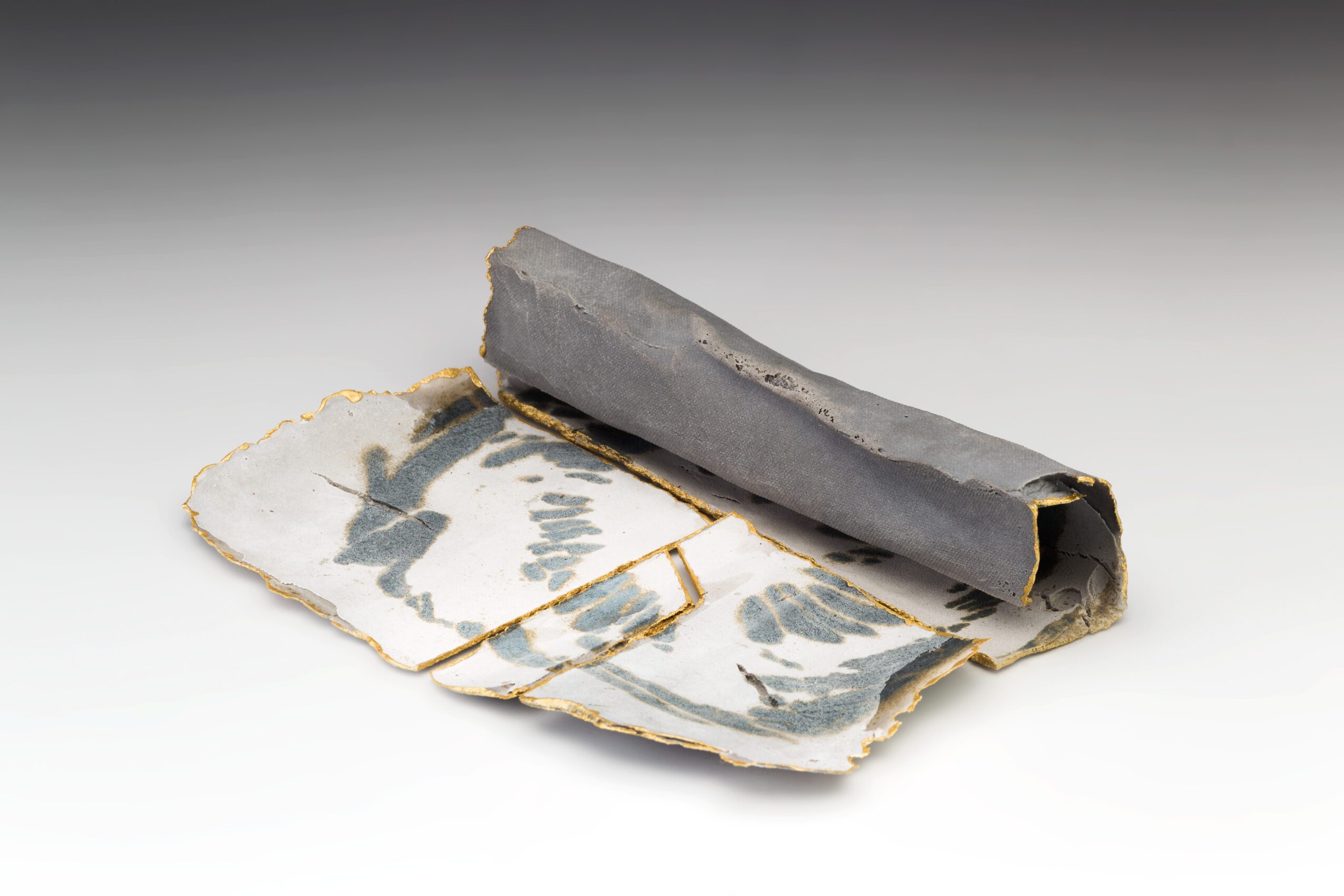 A rolled-up piece of paper with black and white abstract patterns, partially unrolled to reveal the design.