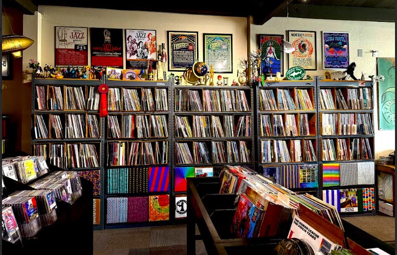 Bookshelves filled with books and magazines in a store or library, with some colorful items on display.