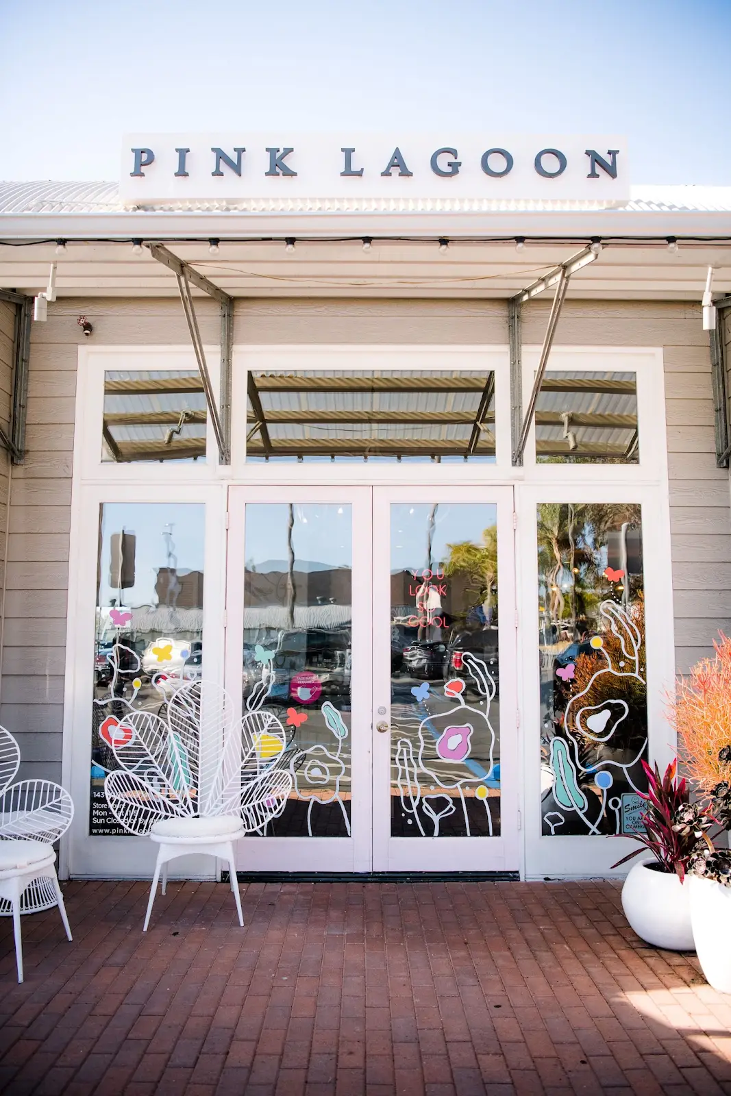 Storefront with glass doors and windows, chairs outside, and a sign reading 'Pink Lagoon' above the entrance.