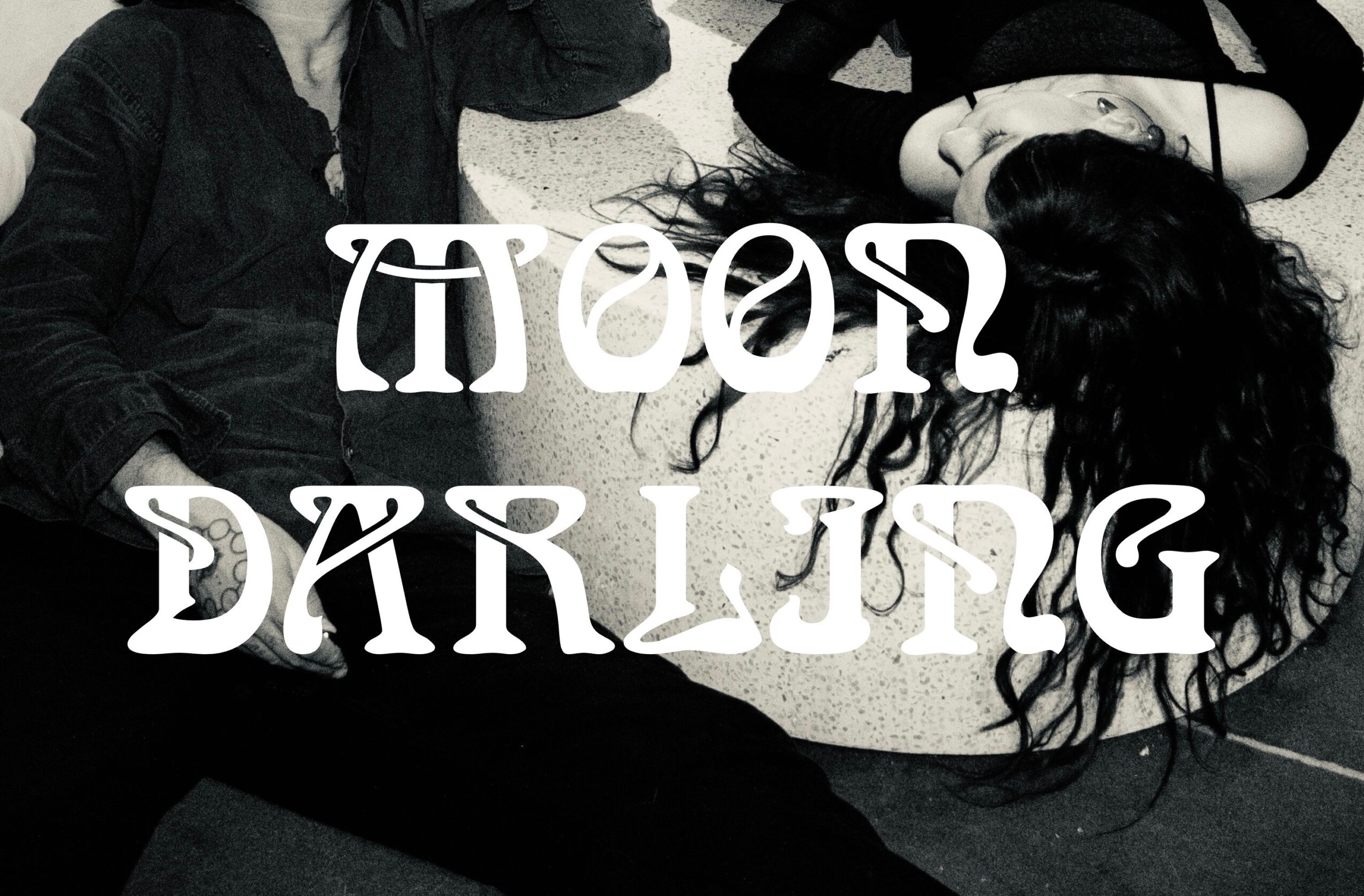 Two people lying on the floor with text overlay reading 'Moon Dancing' in stylized font.