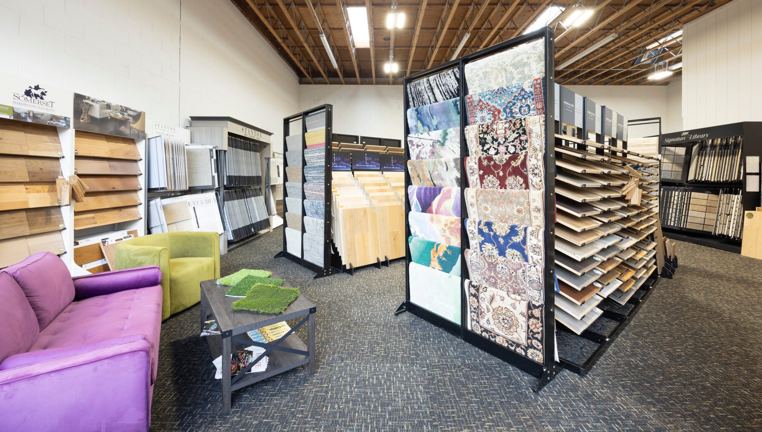 Furniture and fabric samples displayed in a store, with shelves and a purple sofa visible.