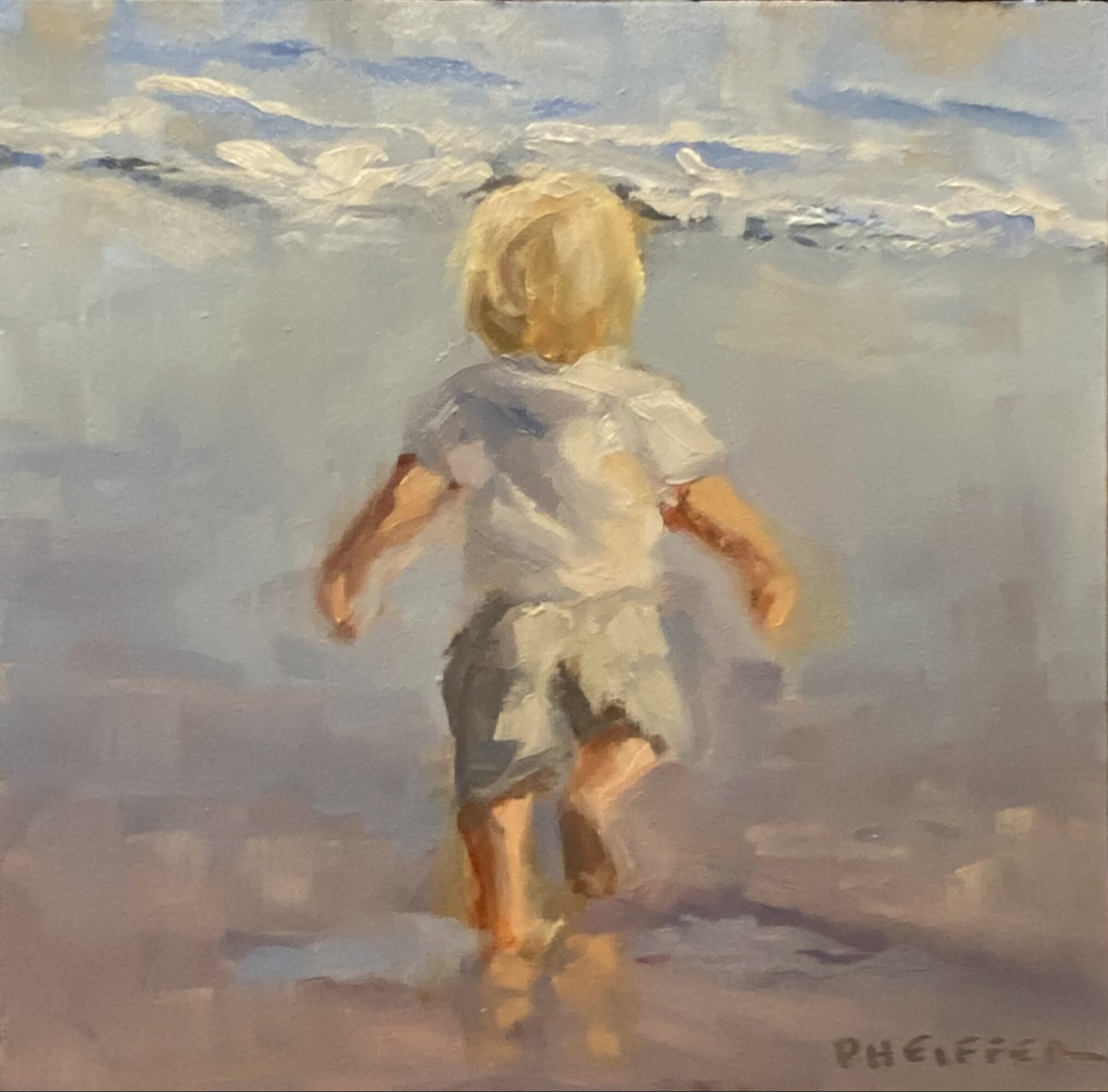 Child with blonde hair walking into the water at the beach, facing away, wearing a light shirt and shorts.