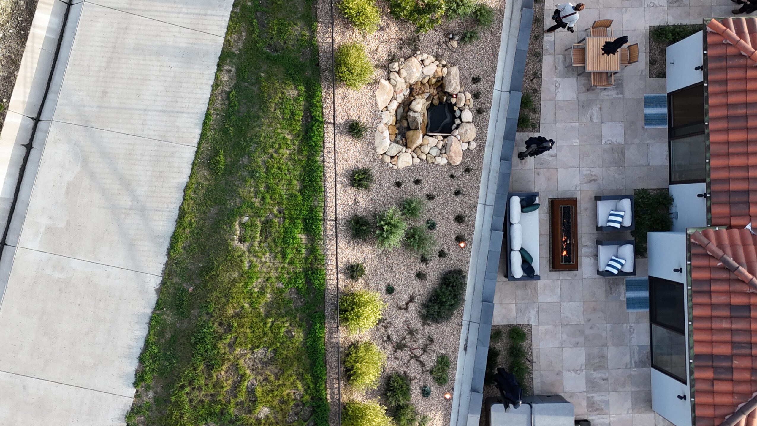 Aerial view of a garden with a fire pit, plants, and a patio with outdoor furniture.